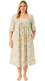 Woman wearing a floral nightgown with short sleeves on a white background
