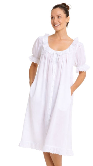 White cotton nightie with puff sleeves, lace trim neckline and button front with pockets.