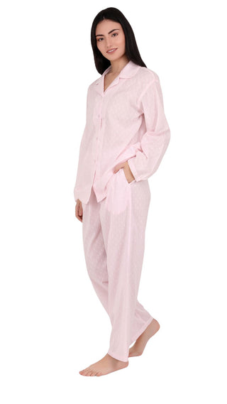 Woman wearing pink long pajamas on a white background