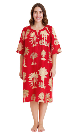 Woman wearing a red dress with palm tree patterns on a white background